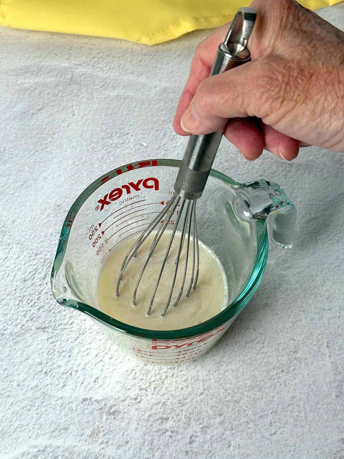 Whisking milk, sugar and nonfat milk.