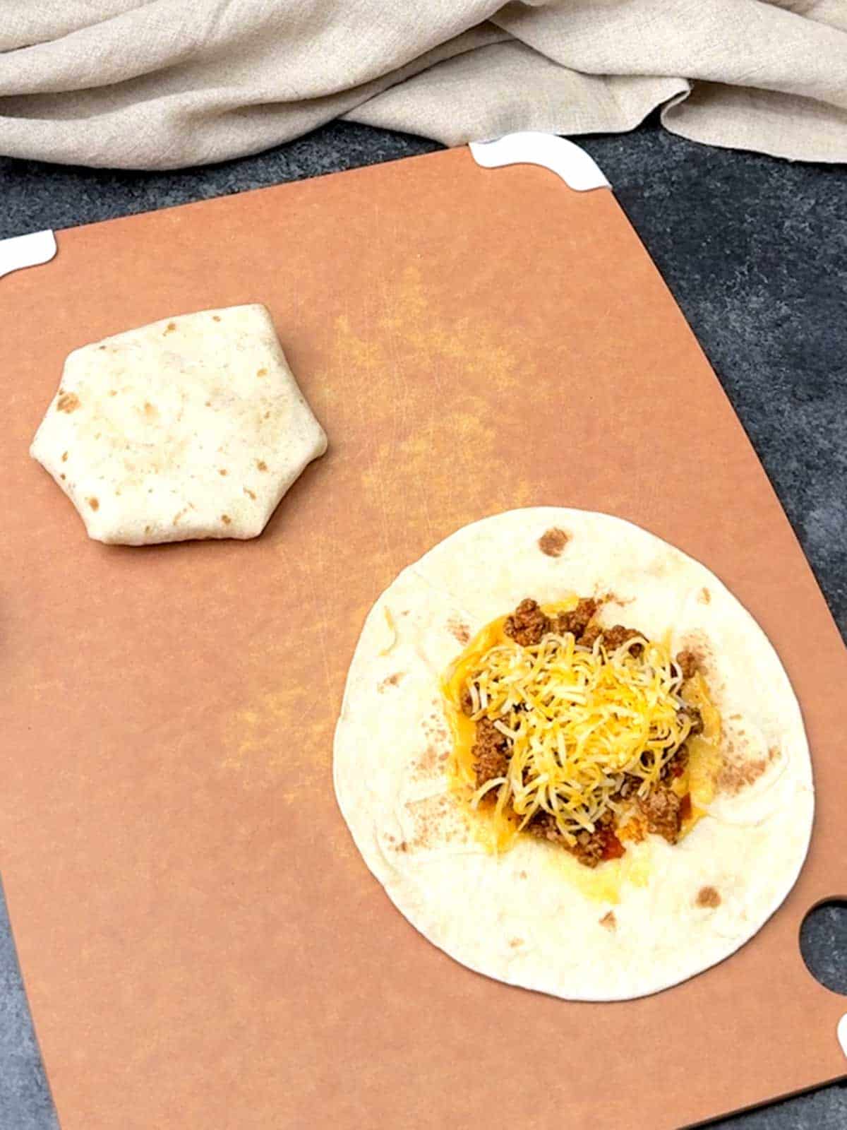 Adding shredded cheese.