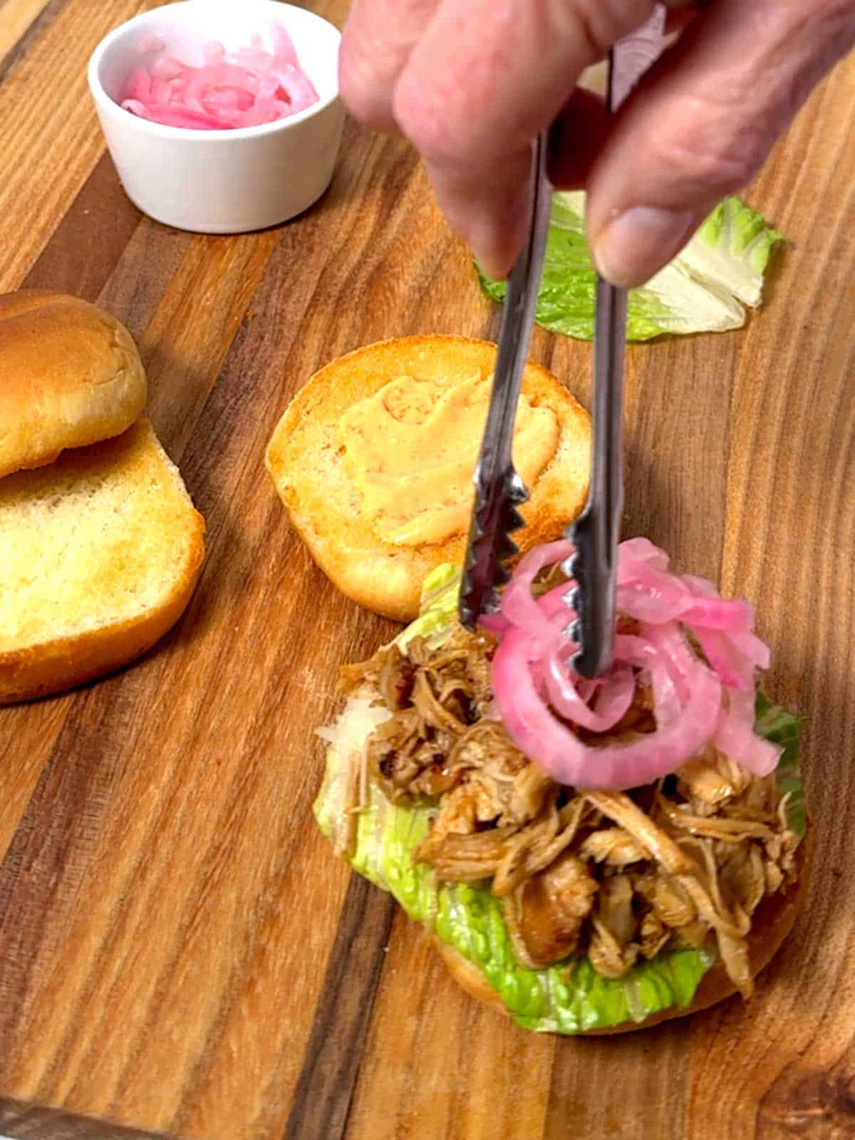 Adding pickled red onions.