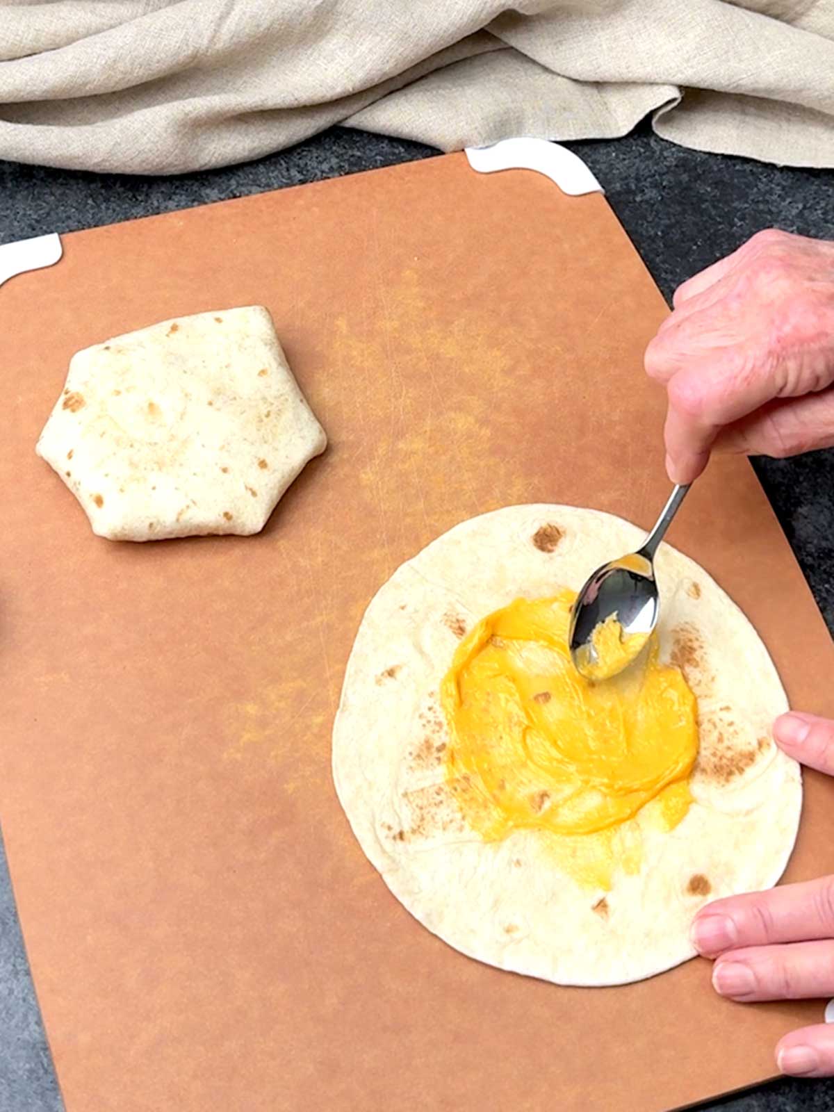 Adding the Salsa con Queso to the tortilla.