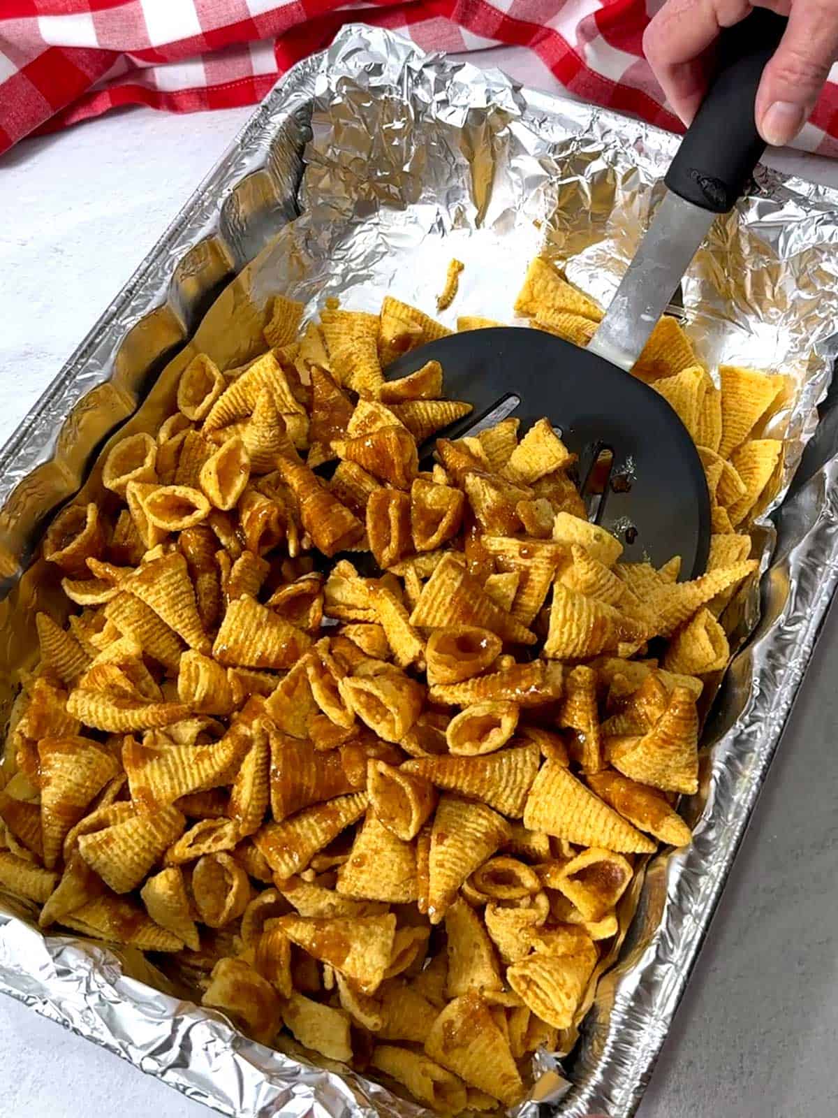 Tossing the Bugles with the caramel using a wide hamburger turner.