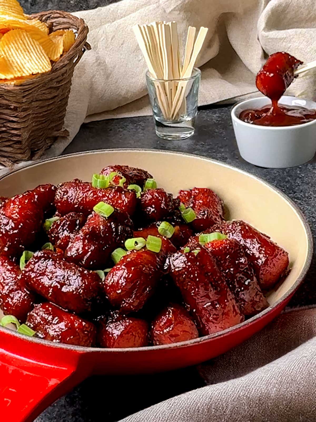 Hot dog burnt ends dipped into BBQ sauce.