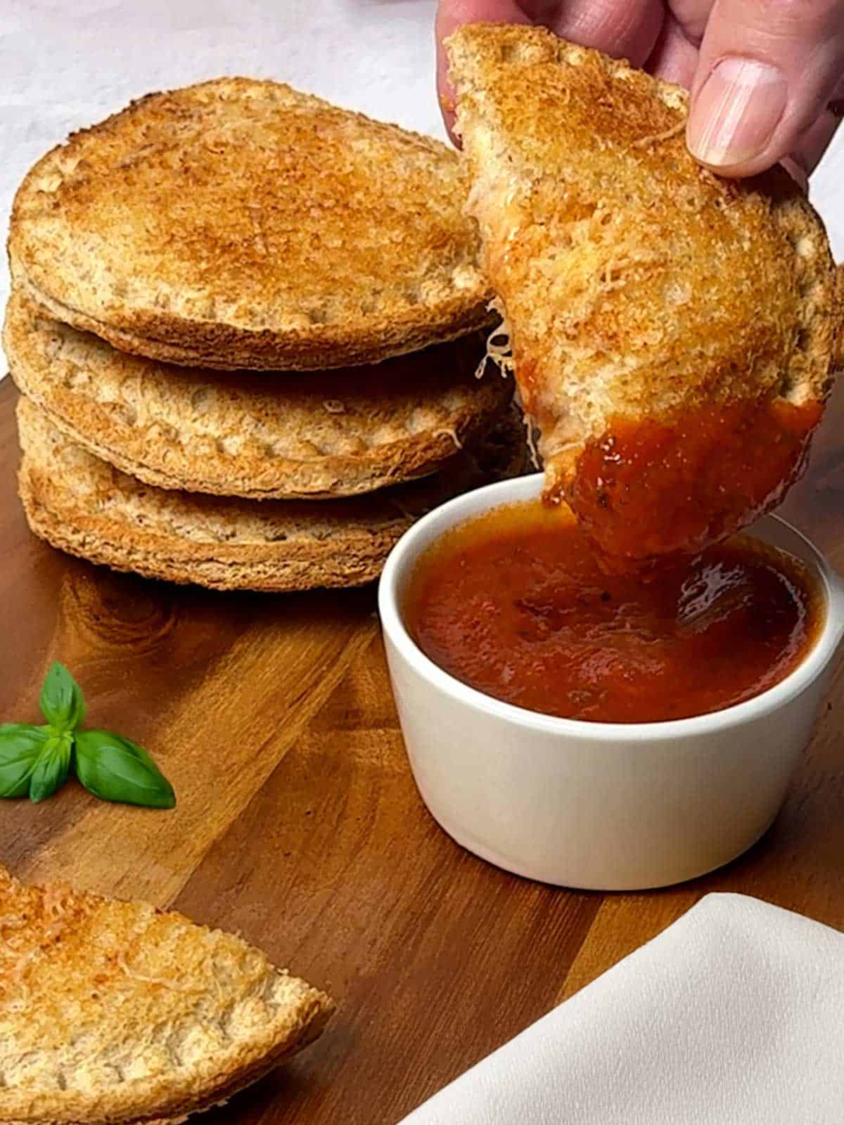 Dipping uncrustable in pizza sauce.