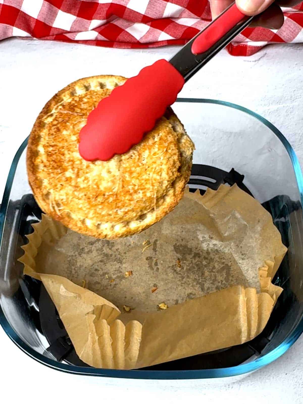 Removing the Uncrustable from the Air Fryer.
