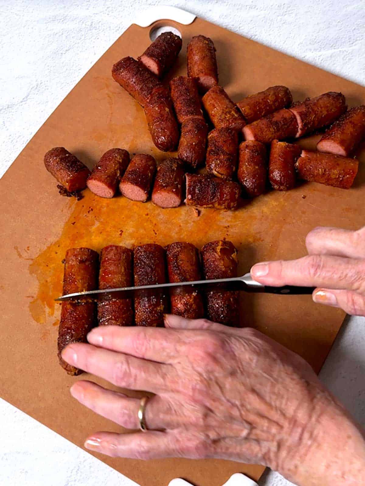 Slicing the cooked hot dogs.