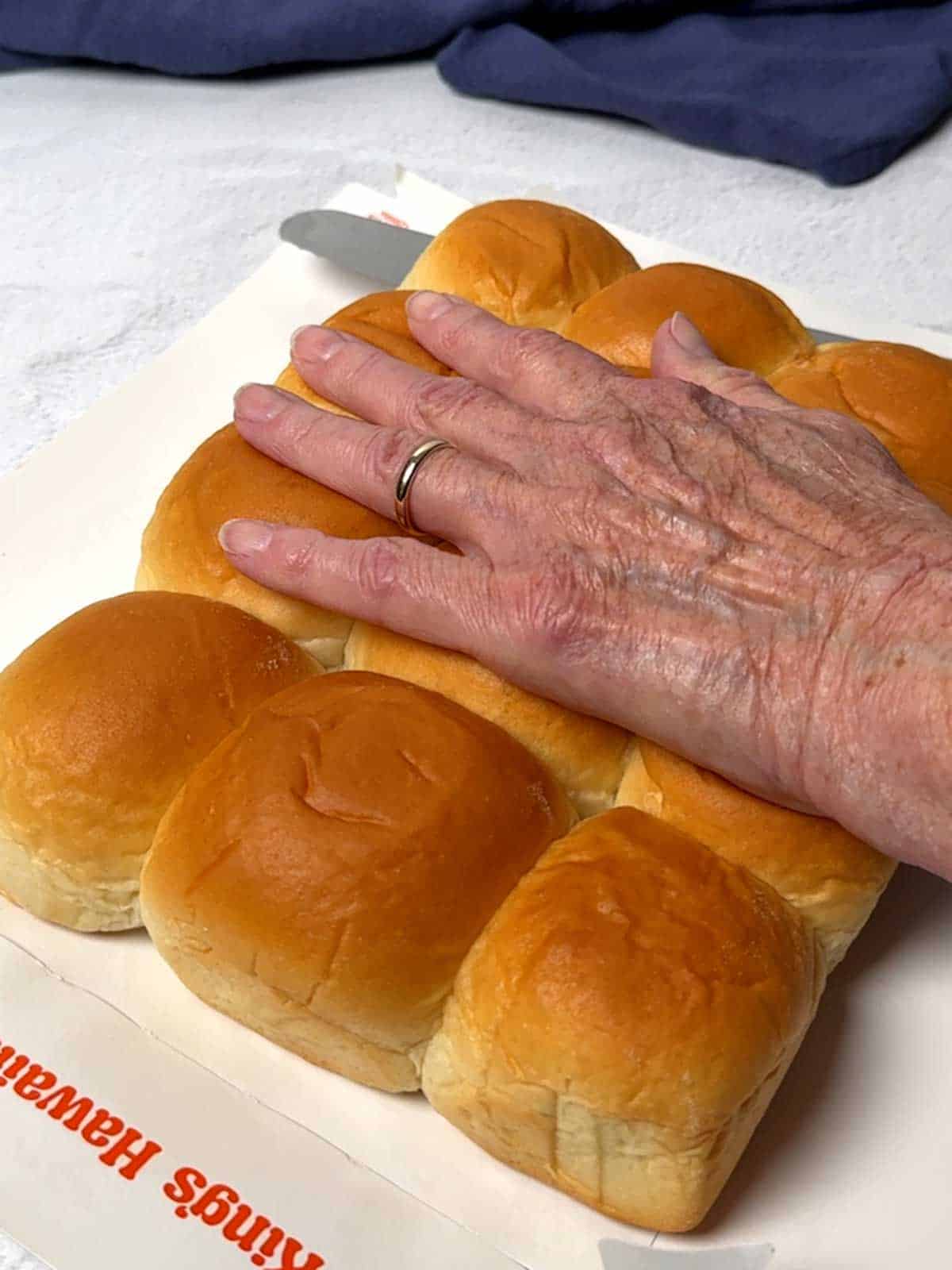 Slicing the Hawaiian rolls in half horizontally.