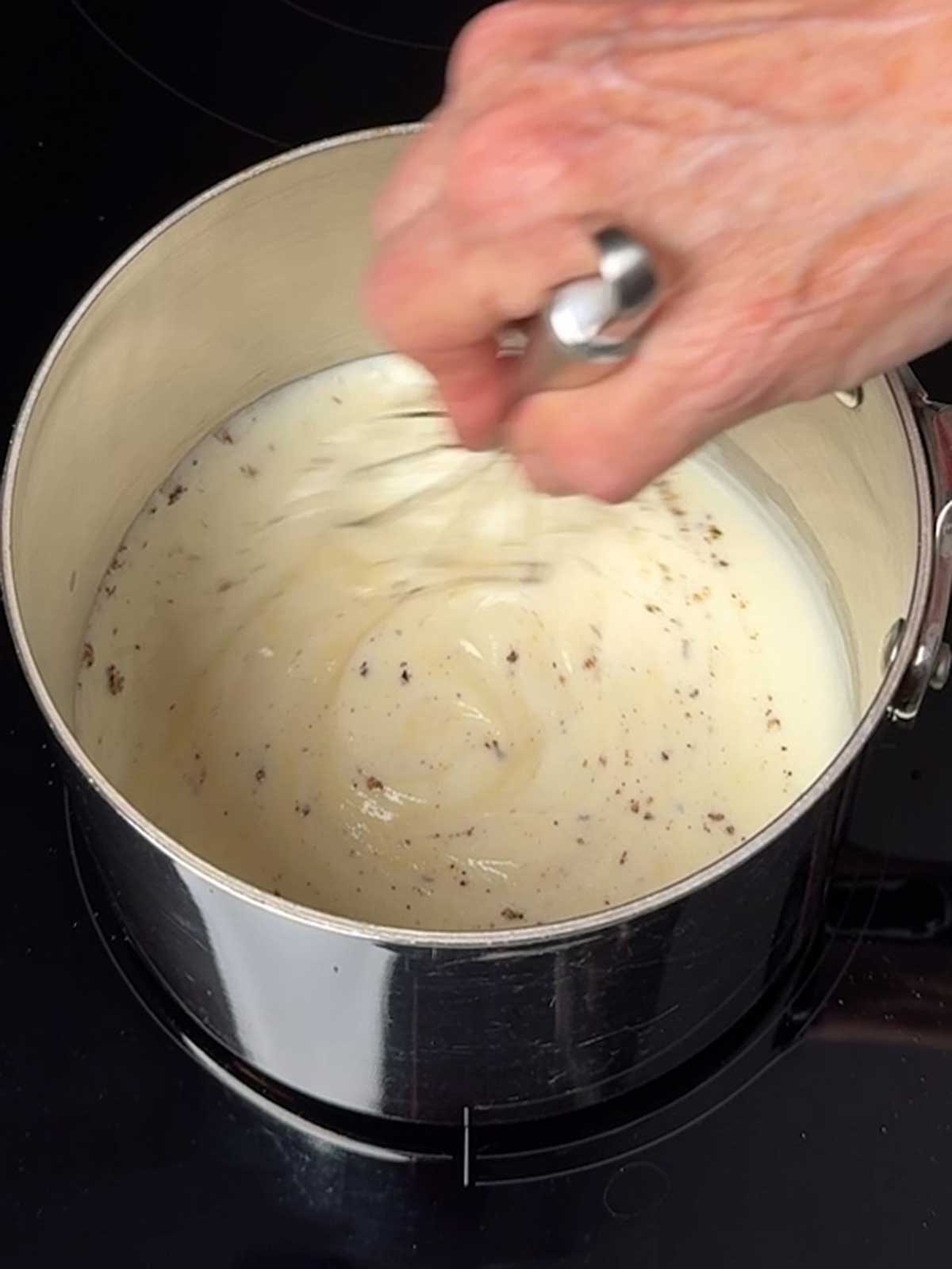 Whisking the bechamel sauce.