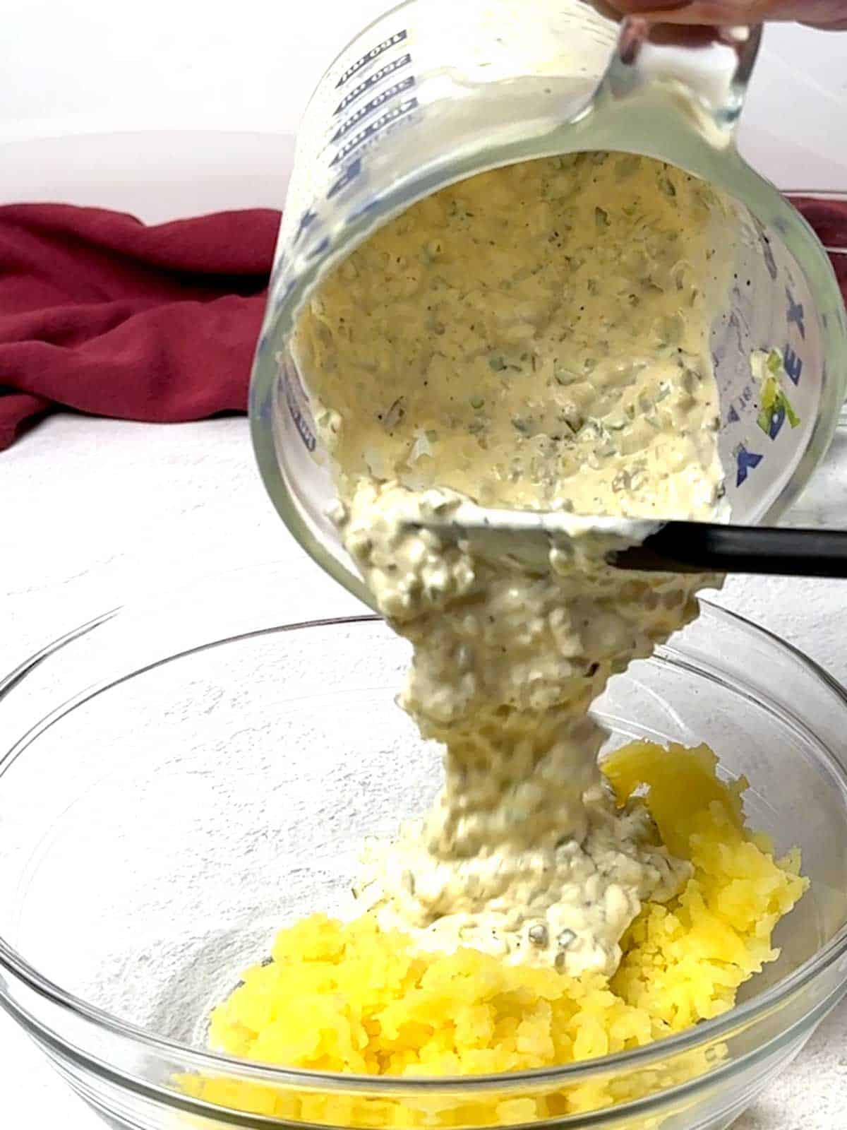 Adding the sauce to the potatoes.