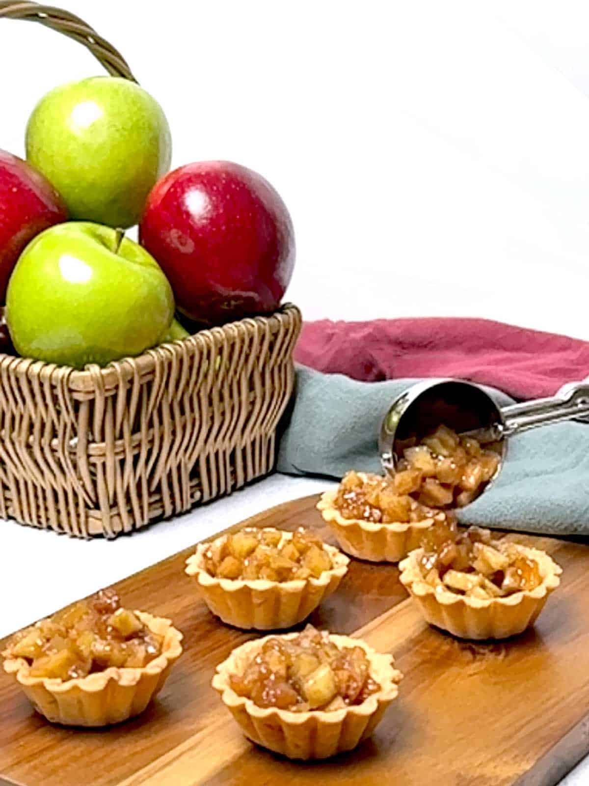 Filling the tart shells with apple filling.