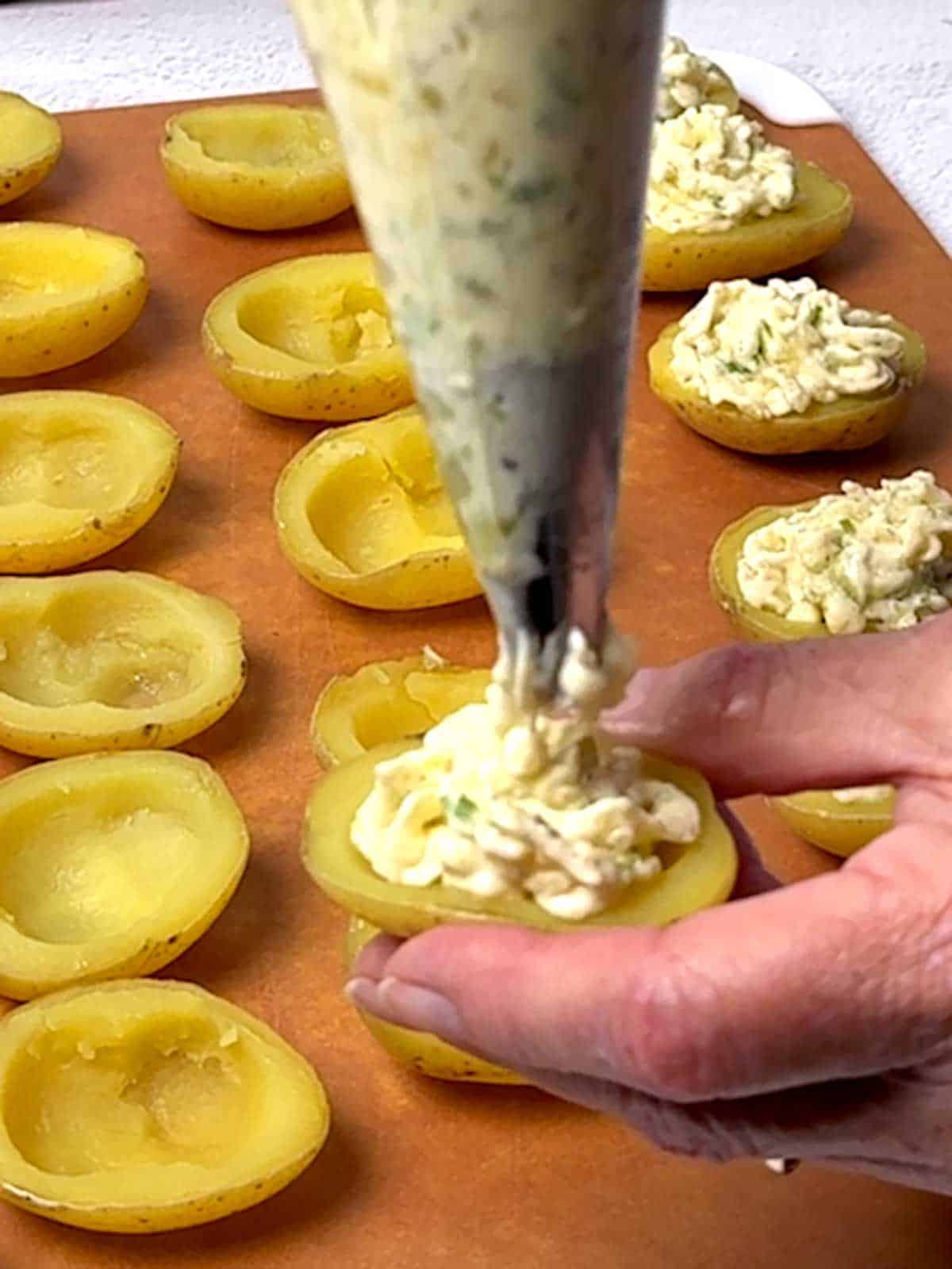 Piping filling into potato shells.