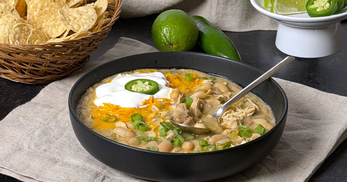 White chicken chili in a bowl with a spoon.