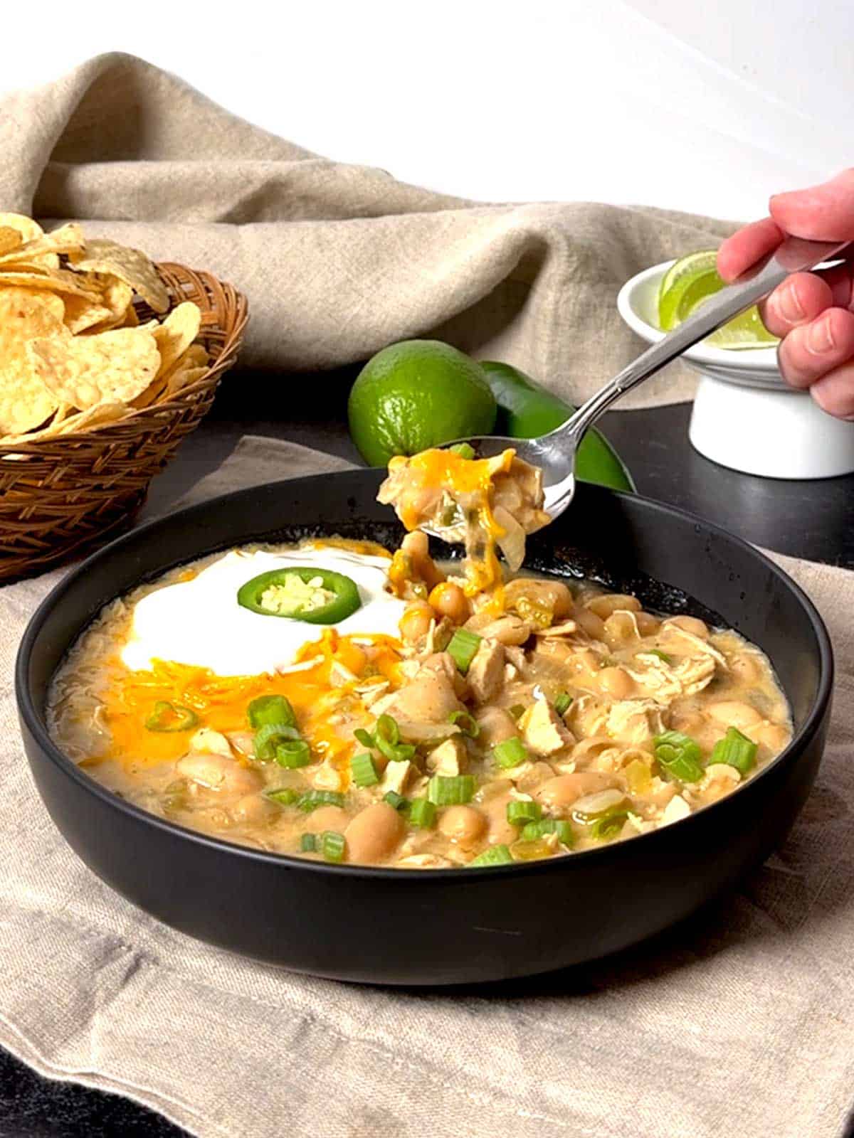 Eating a spoonful of white chicken chili.