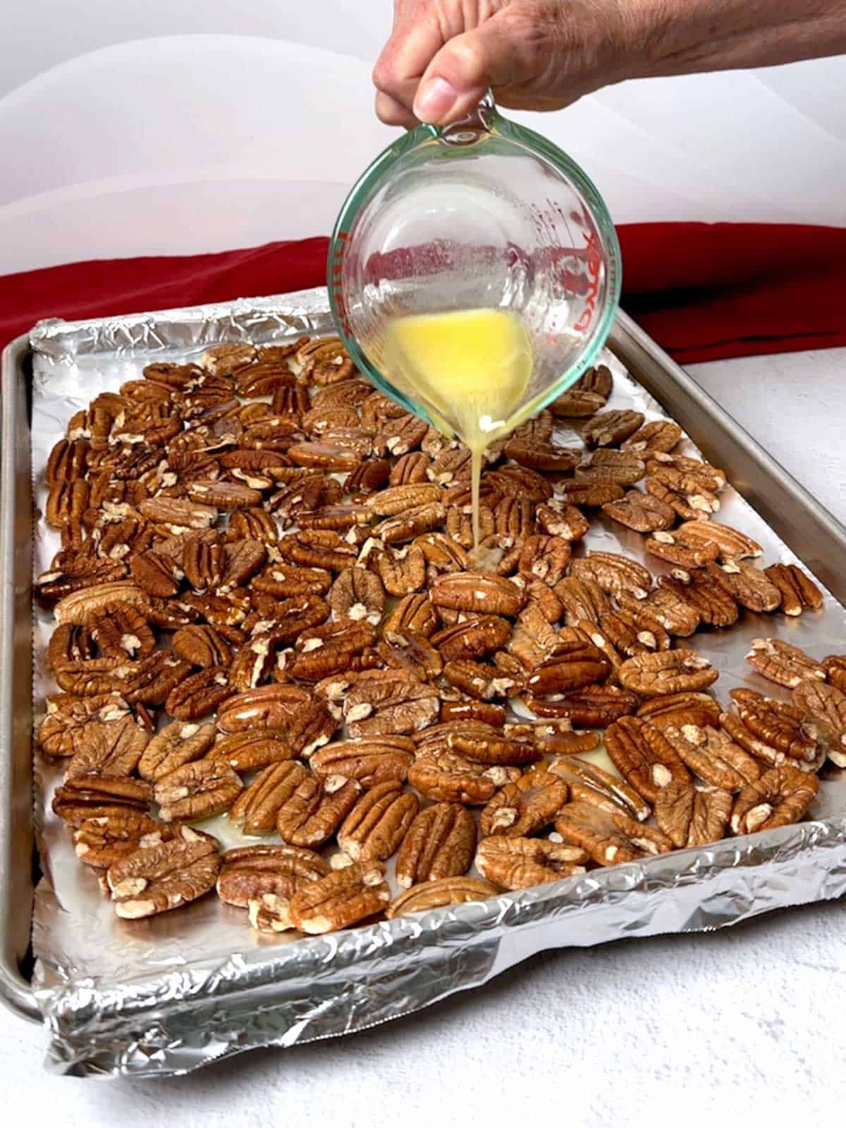 Adding melted butter to the pecans.