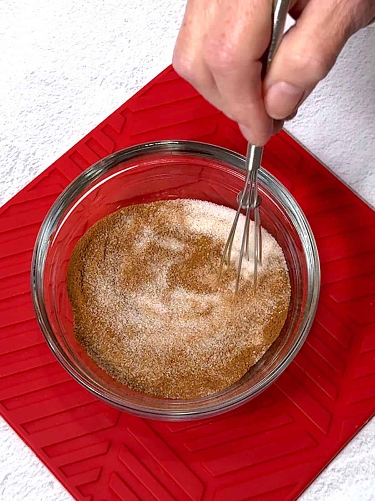 Whisking the sugar and cinnamon together in a small bowl.