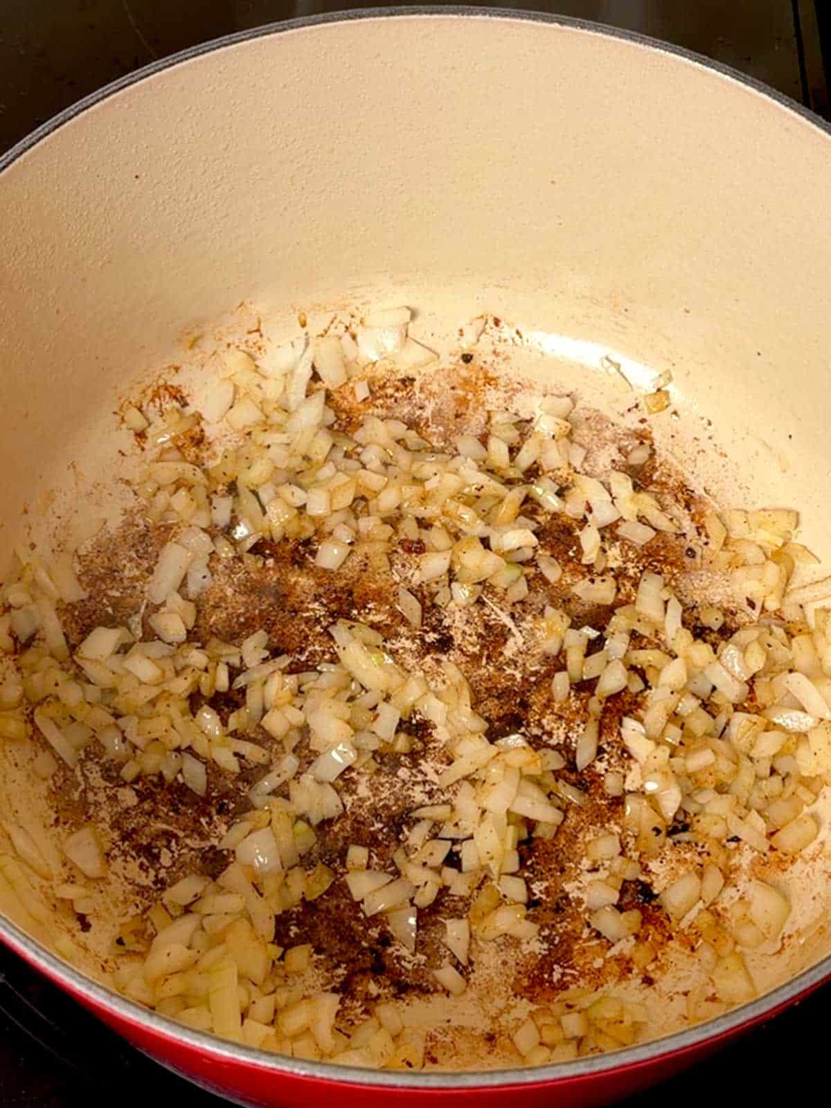 Cooking chopped onions in the Dutch oven.
