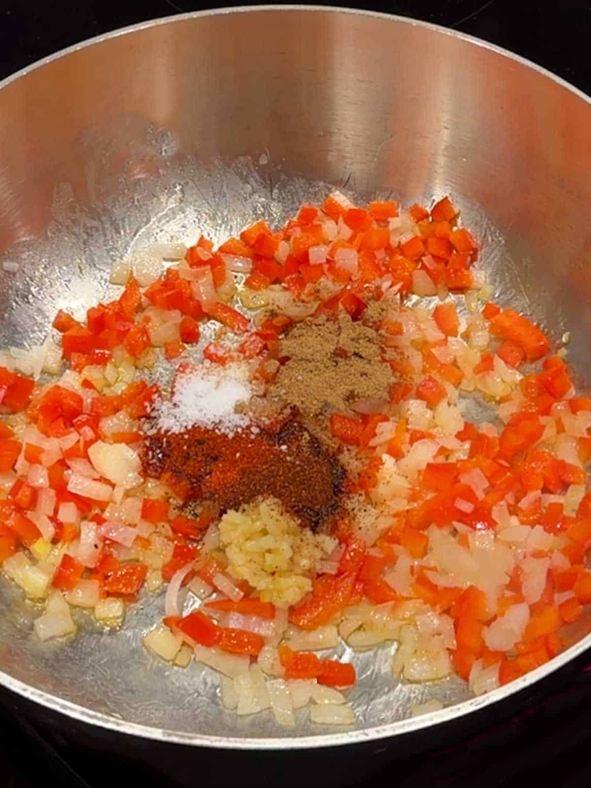 Cooking the onion, red bell pepper, garlic, and spices.