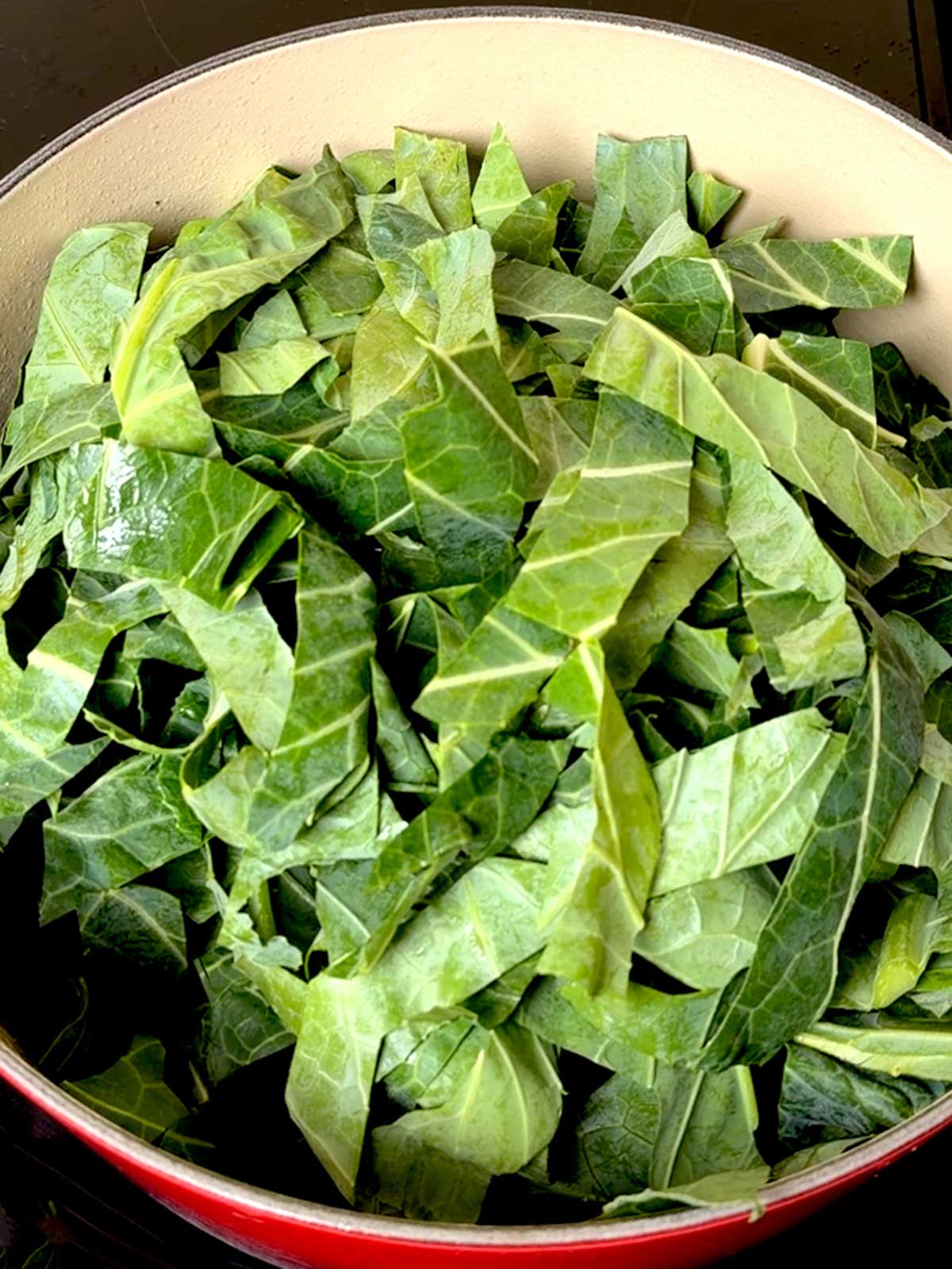 Collard greens added to the Dutch oven.