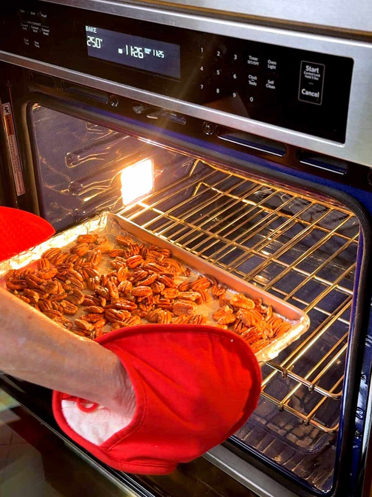 Returning pecans to the oven for the slow roast.