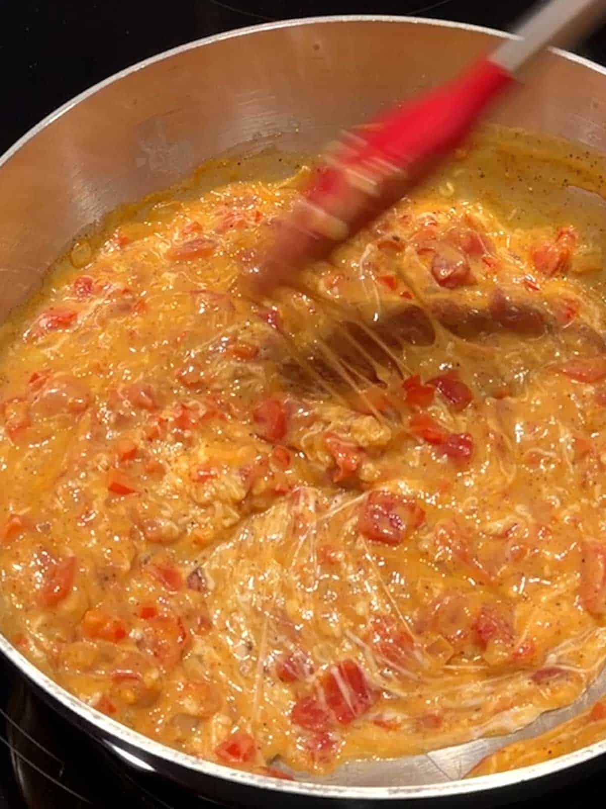 Stirring the sauce with the cheese.