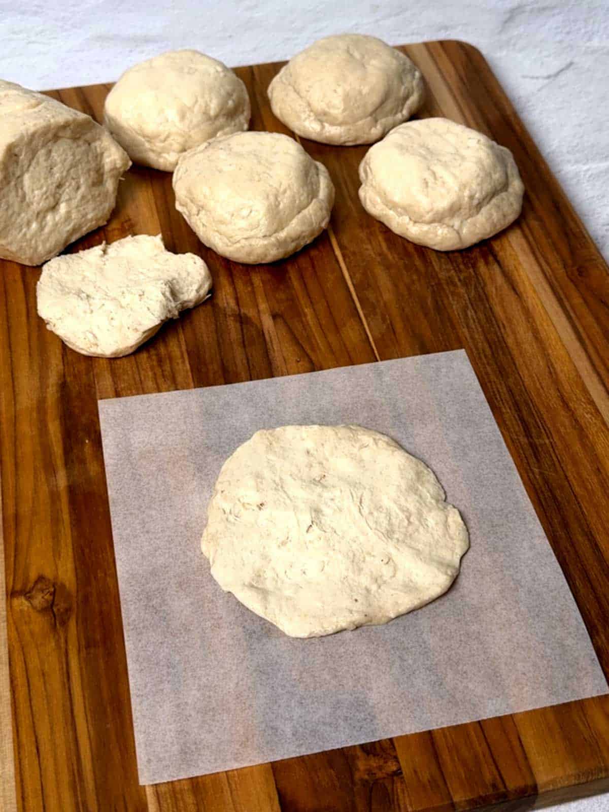 Half of the refrigerated biscuit stretched and on a piece of parchment paper.