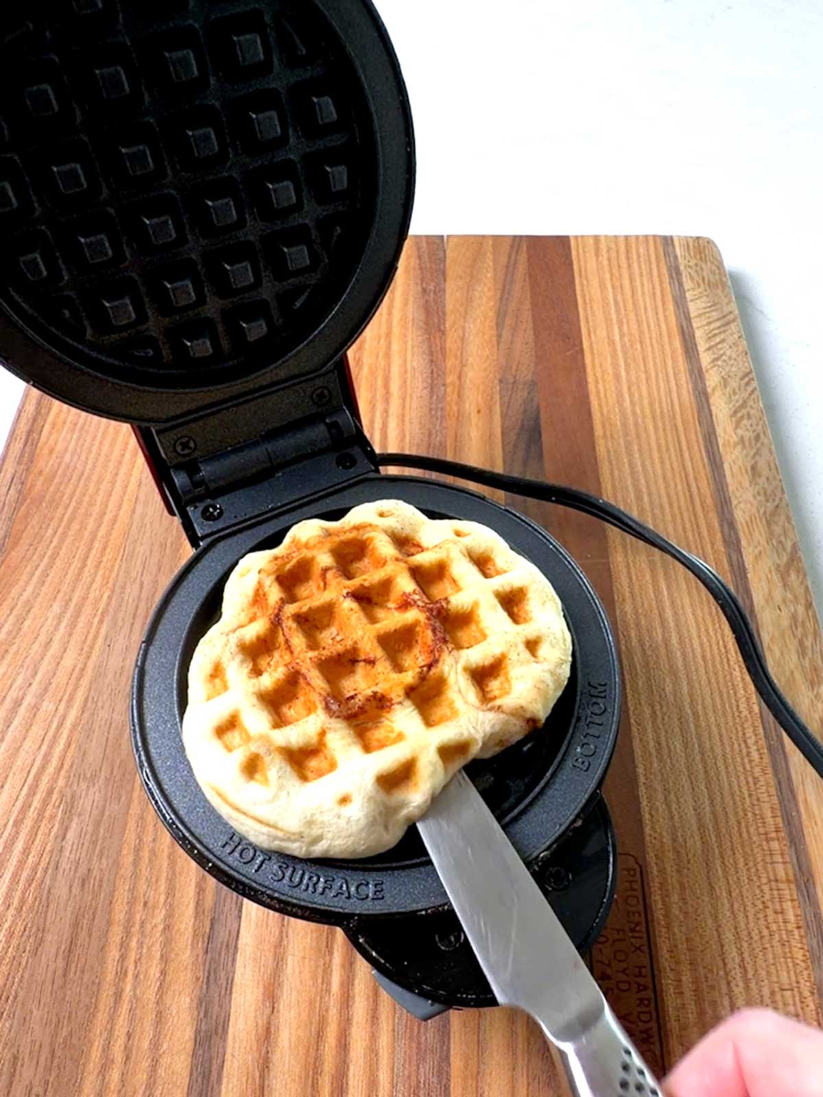 Cutting the channel in the partially cooked waffle for the popsicle stick.