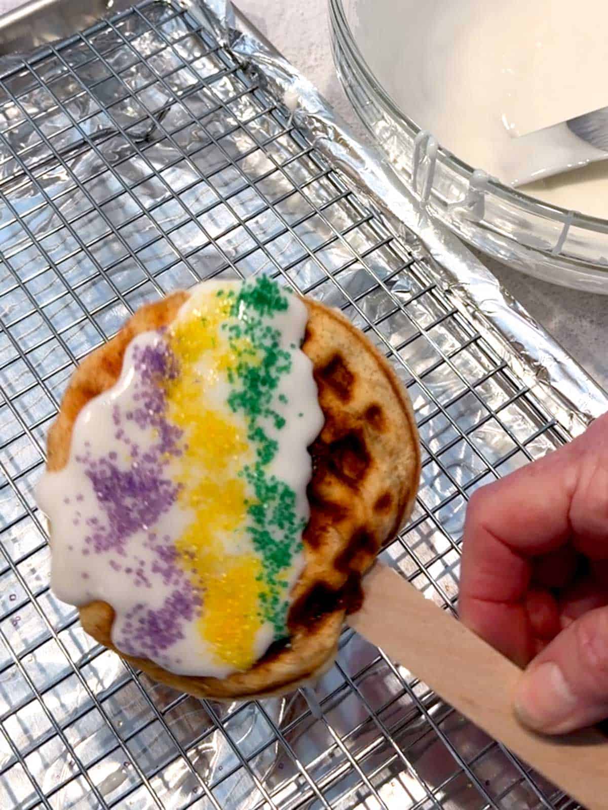 Iced and decorated King Cake Waffle Pop.