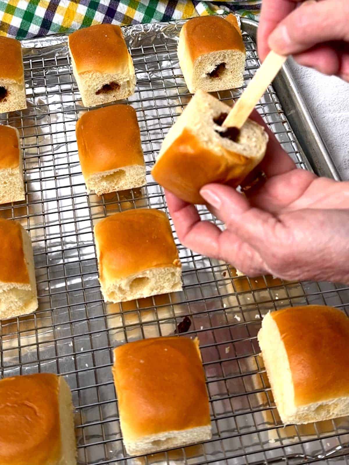 Adding the cinnamon-sugar mixture to the cavity in the Hawaiian roll.