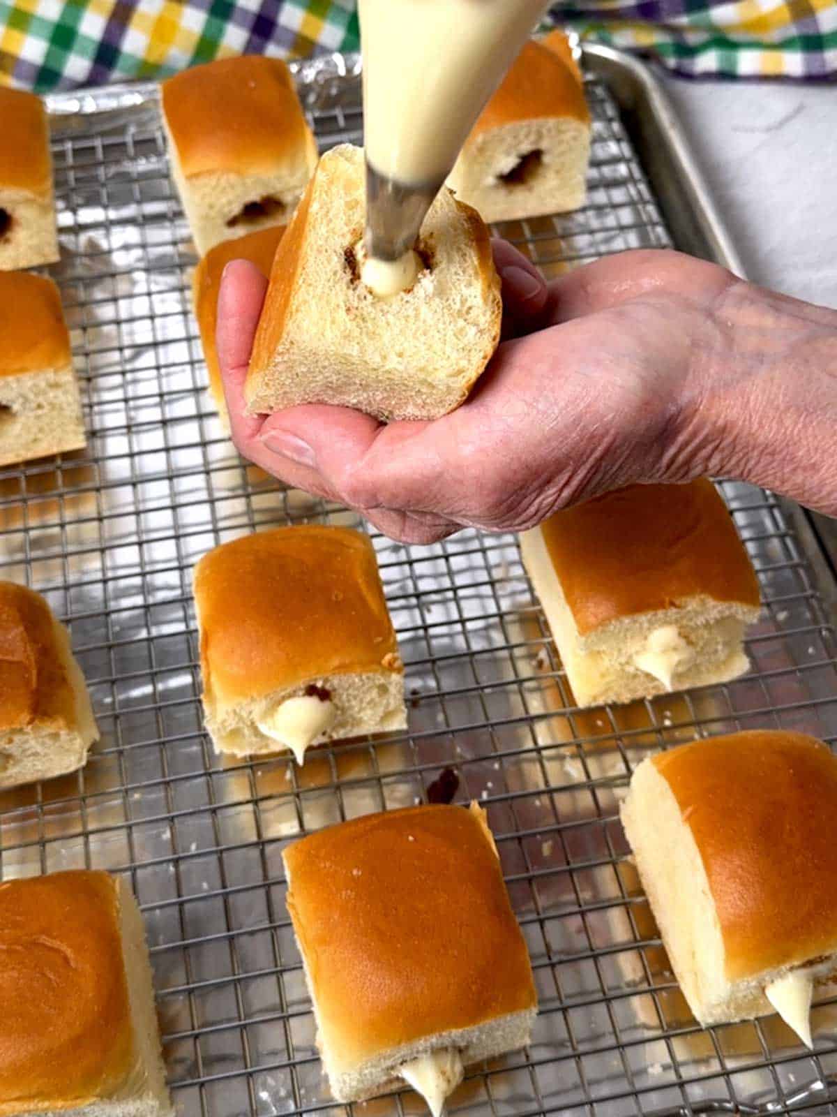 Piping filling intot he cavity of the Hawaiian roll.