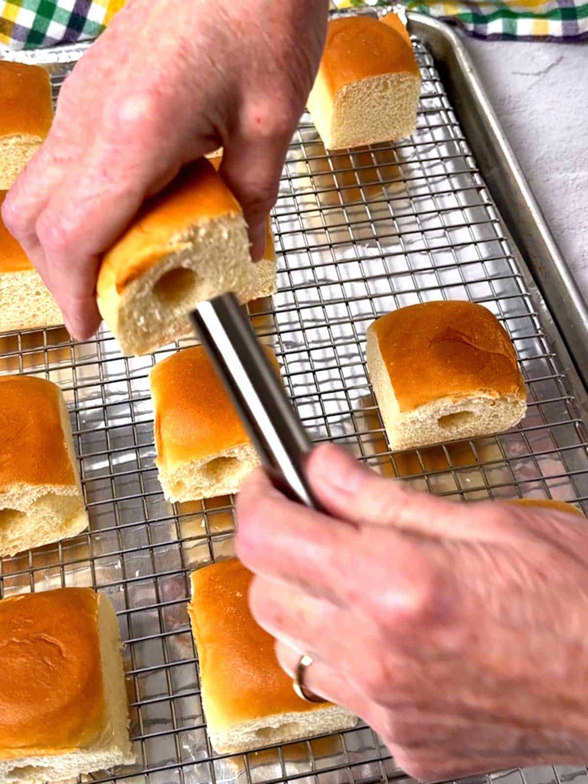 Making a cylindrical core in the side of a Hawaiian roll.