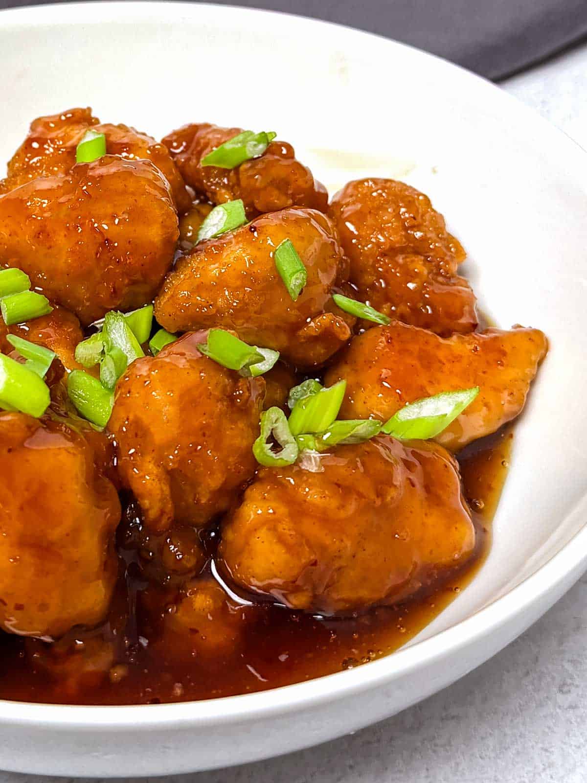 Orange chicken in a white bowl.