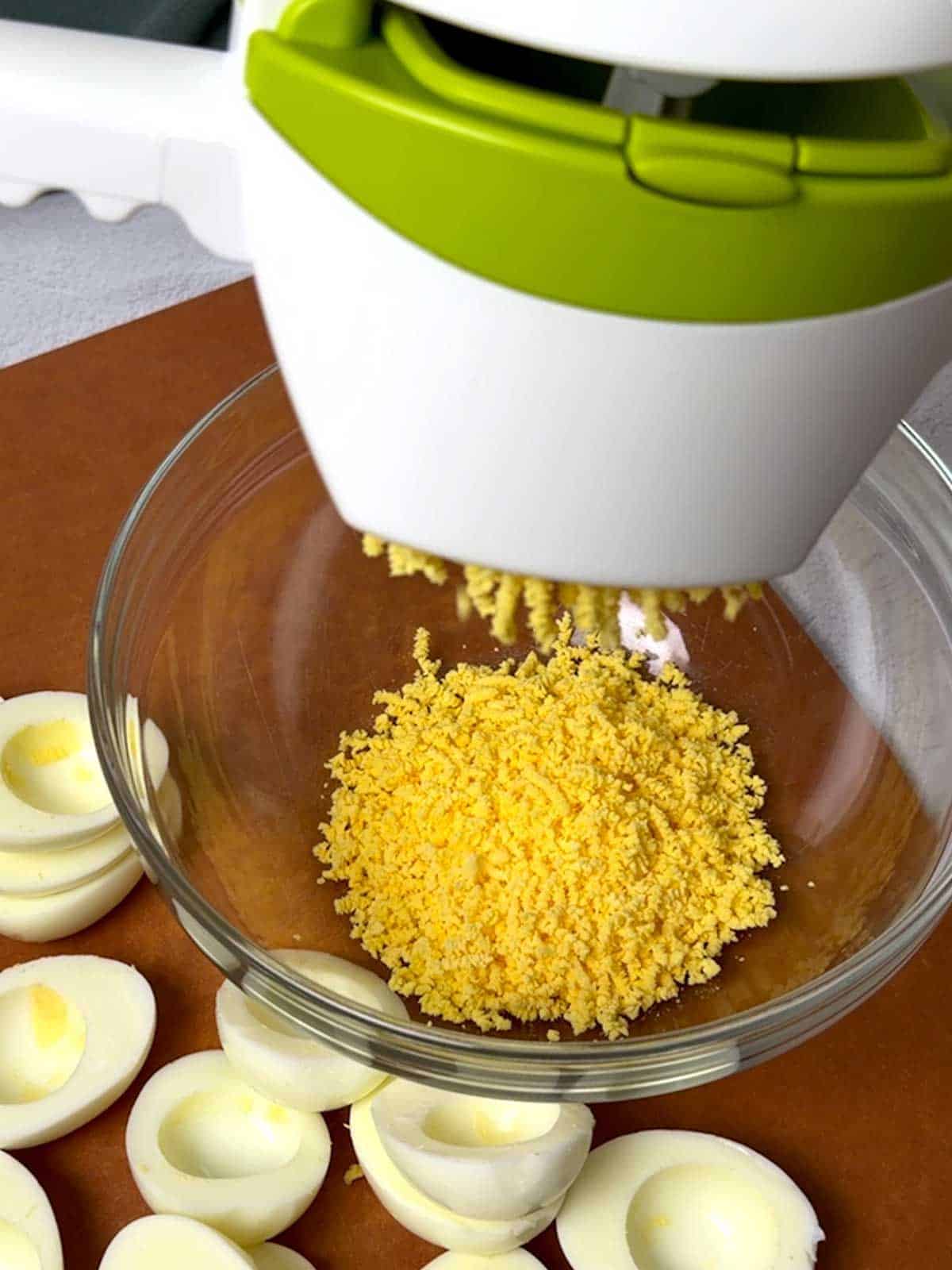 Ricing the egg yolks.