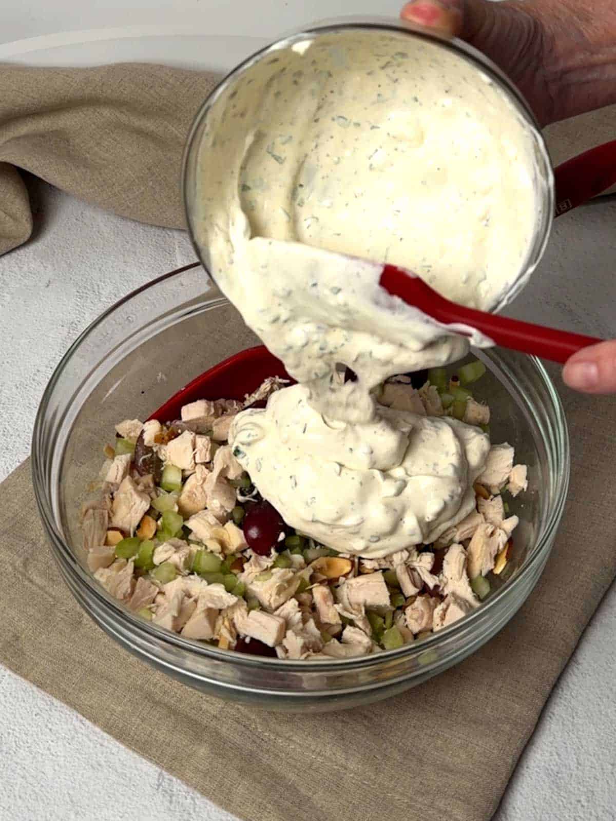 Adding the dressing to the chicken mixture.