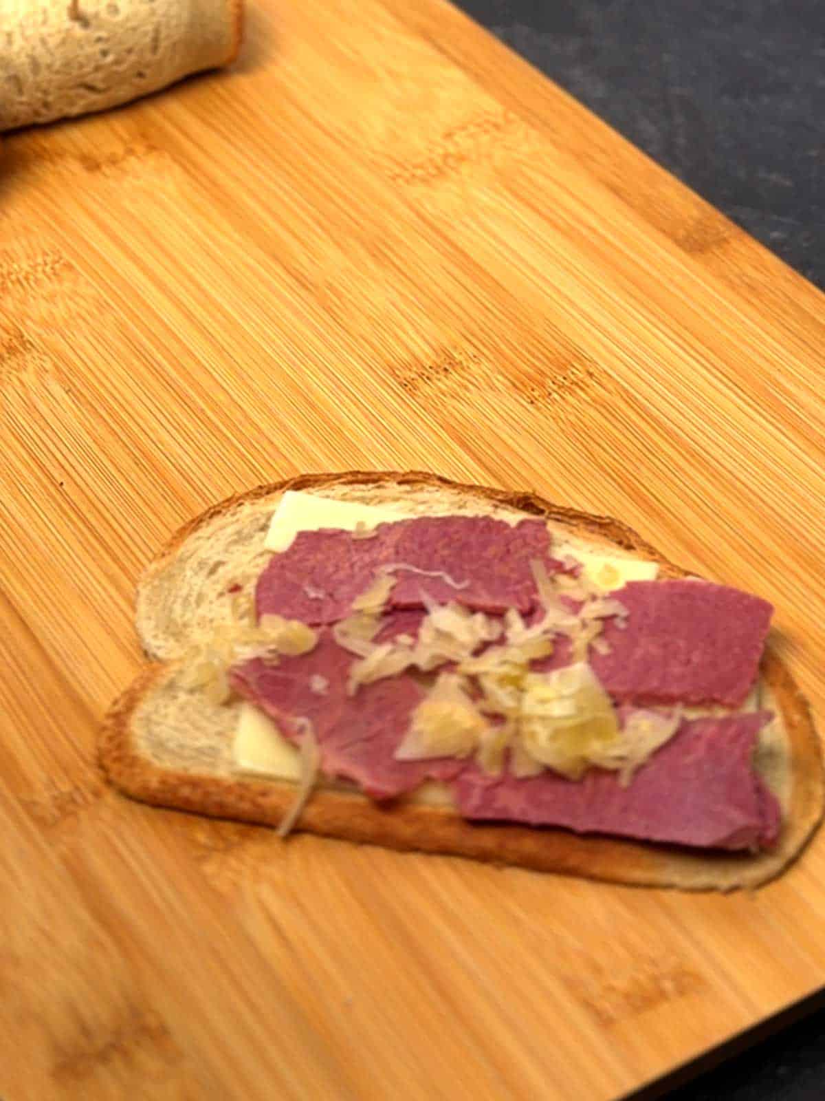 Swiss cheese, corned beef, and sauerkraut on flattened rye bread.