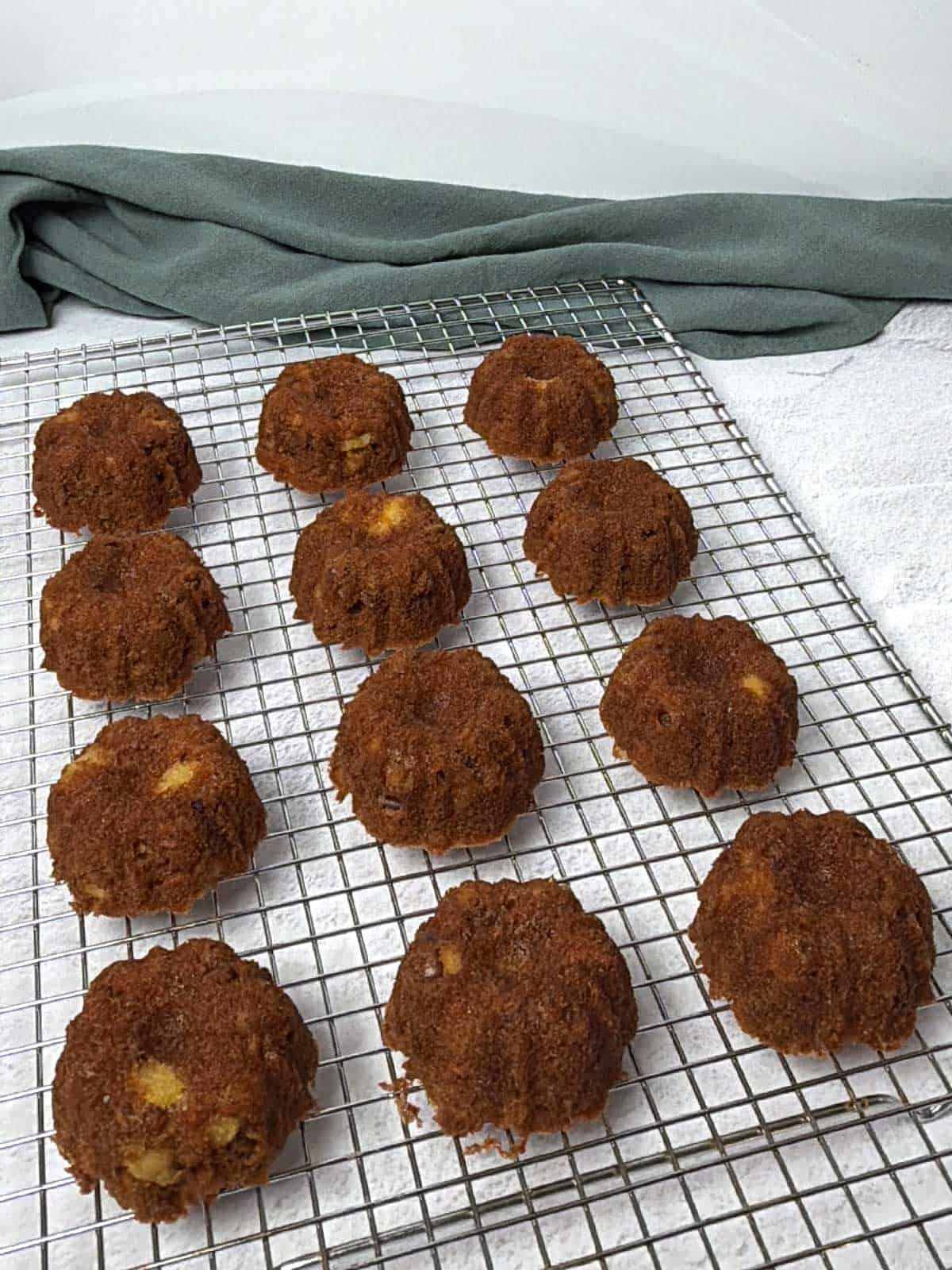 Mini carrot bundt cakes cooking on a wire rack.
