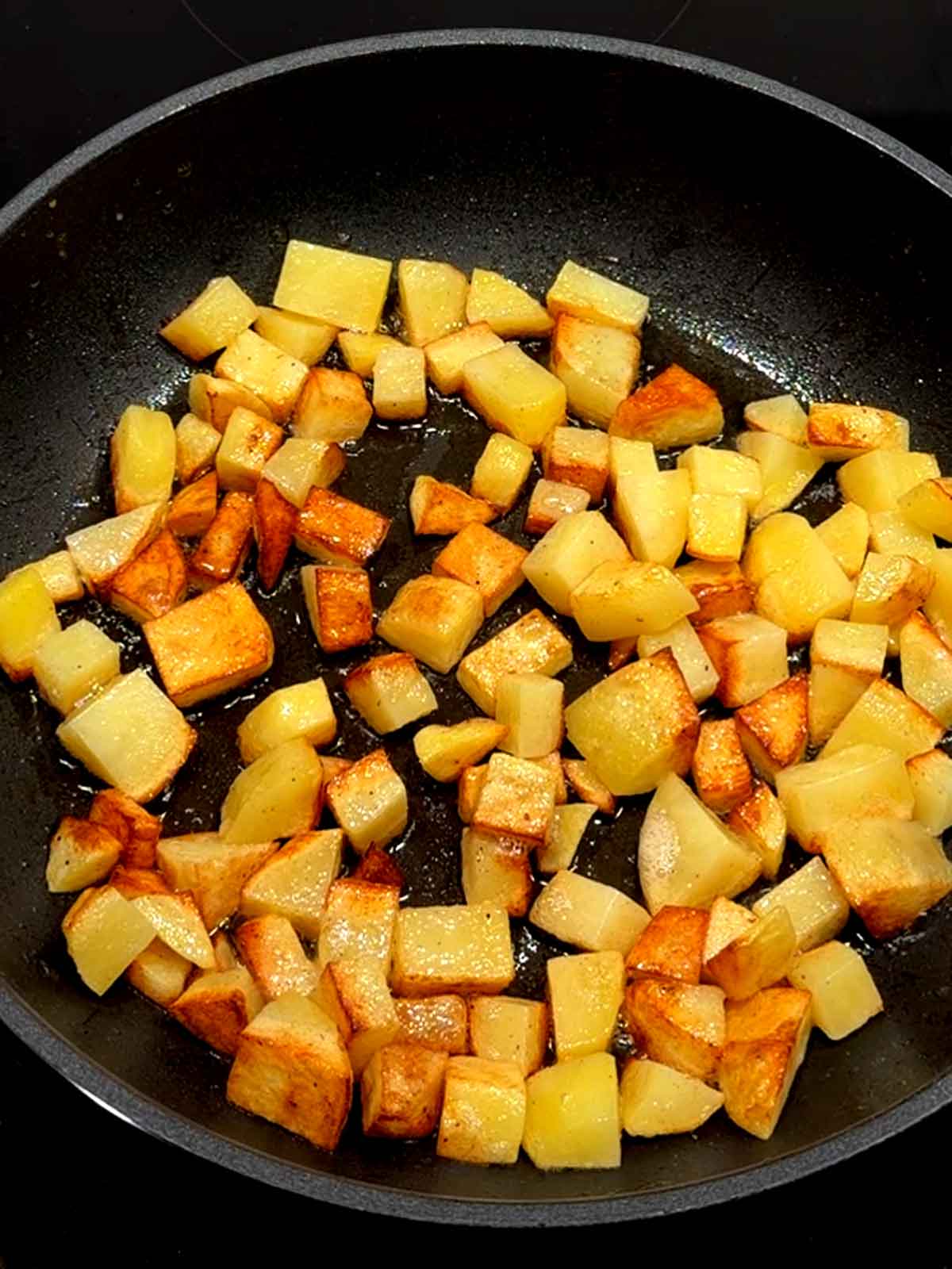 Cooked Potatoes in a large skillet with butter.
