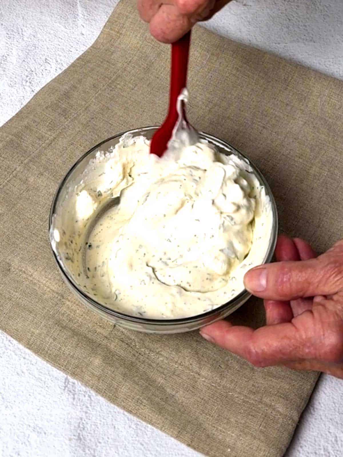 Folding whipped cream into the dressing.