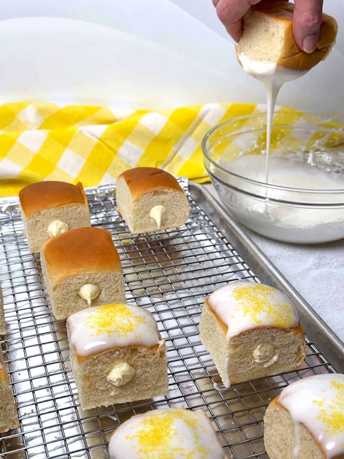 Dipping the tops of the rolls in the glaze.