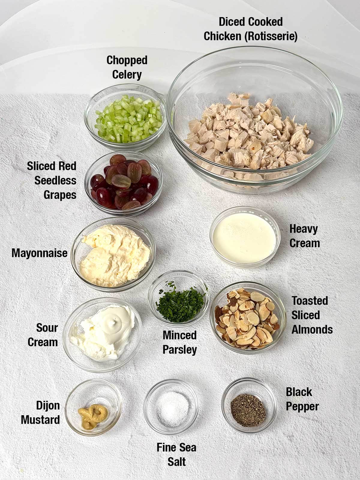 Ingredients used to make the Neiman Marcus Style Chicken Salad: Rotisserie chicken celery, red seedless grapes, mayonnaise, sour cream, heavy cream, toasted almonds, minced parsley, Dijon justard, fine sea salt, and black pepper.
