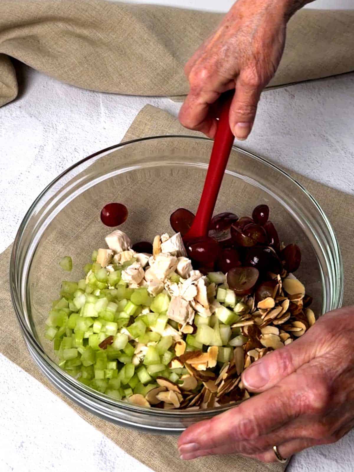 Stirring ingredients for chicken salad together.