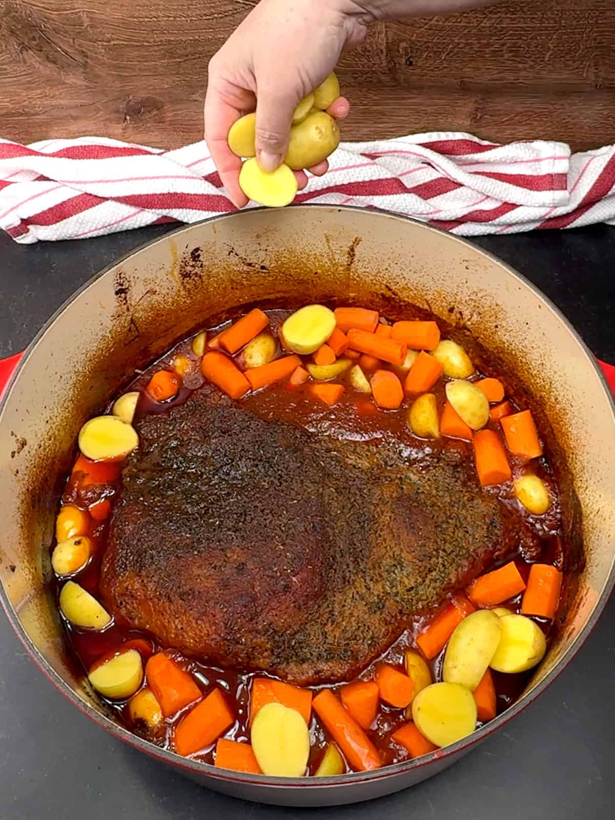adding carrot pieces and baby gold potatoes to pot