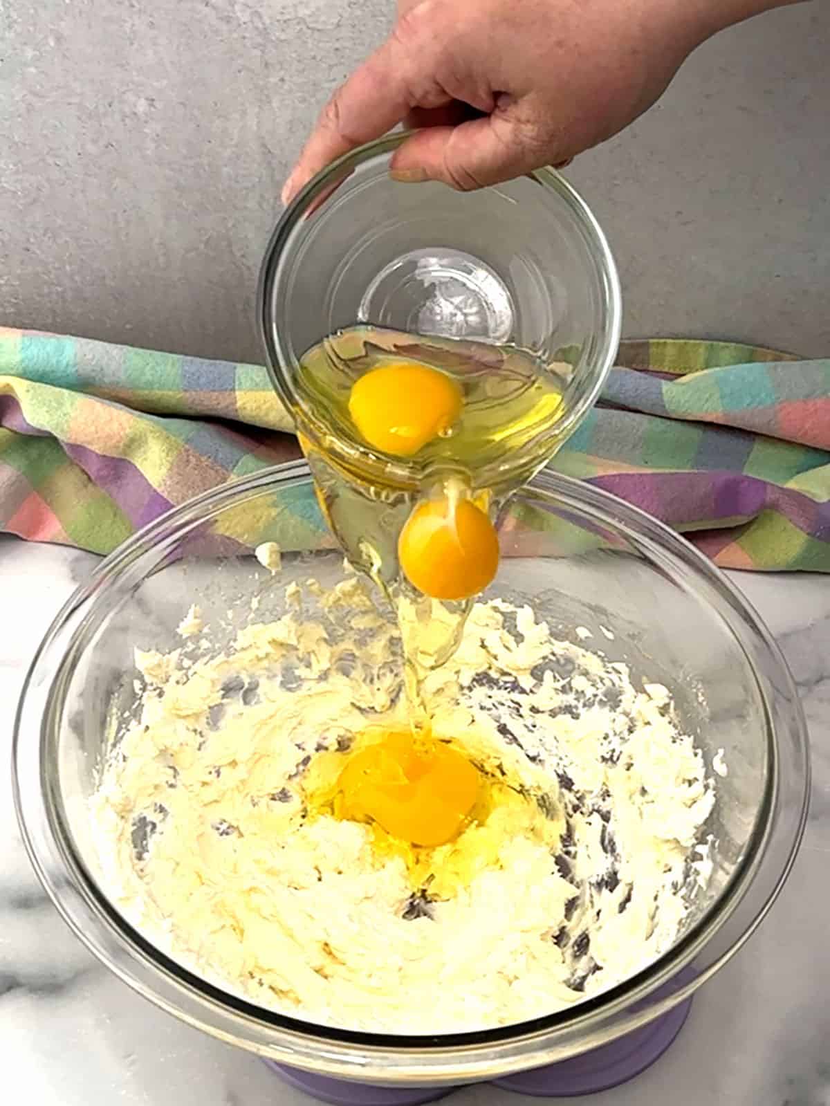 adding eggs to cream cheese mixture