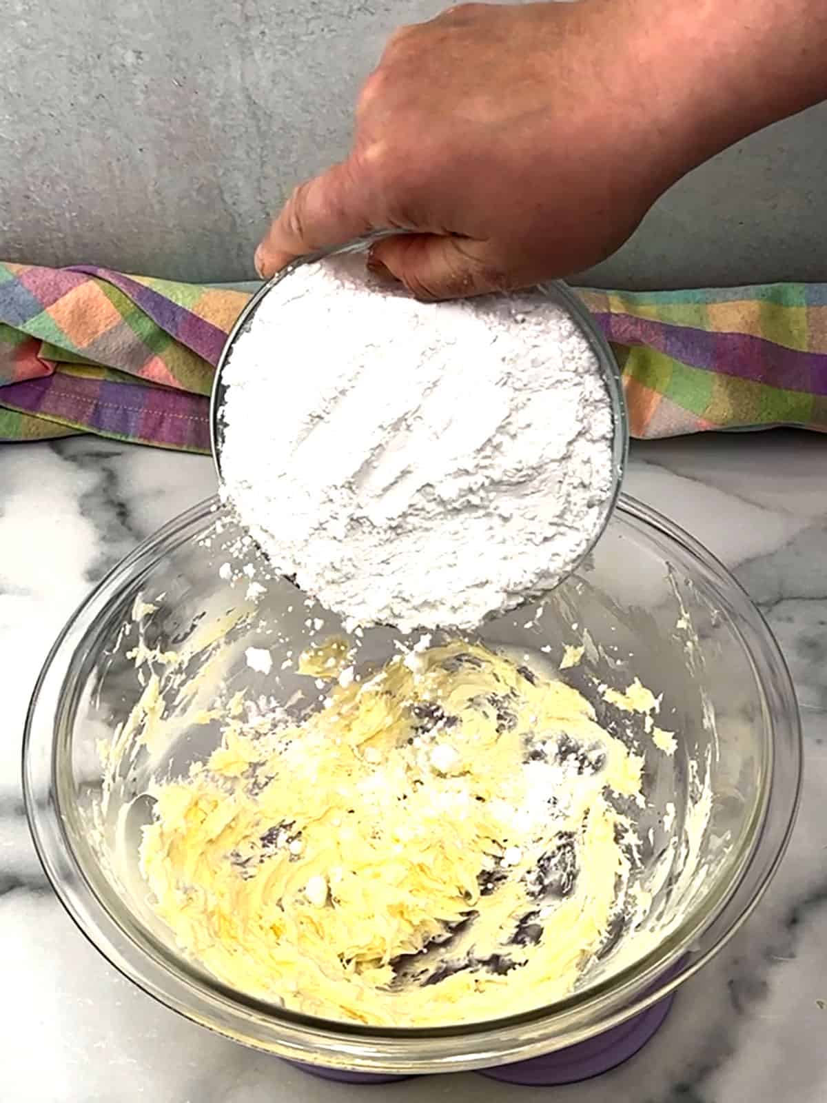 adding powdered sugar to butter for frosting.