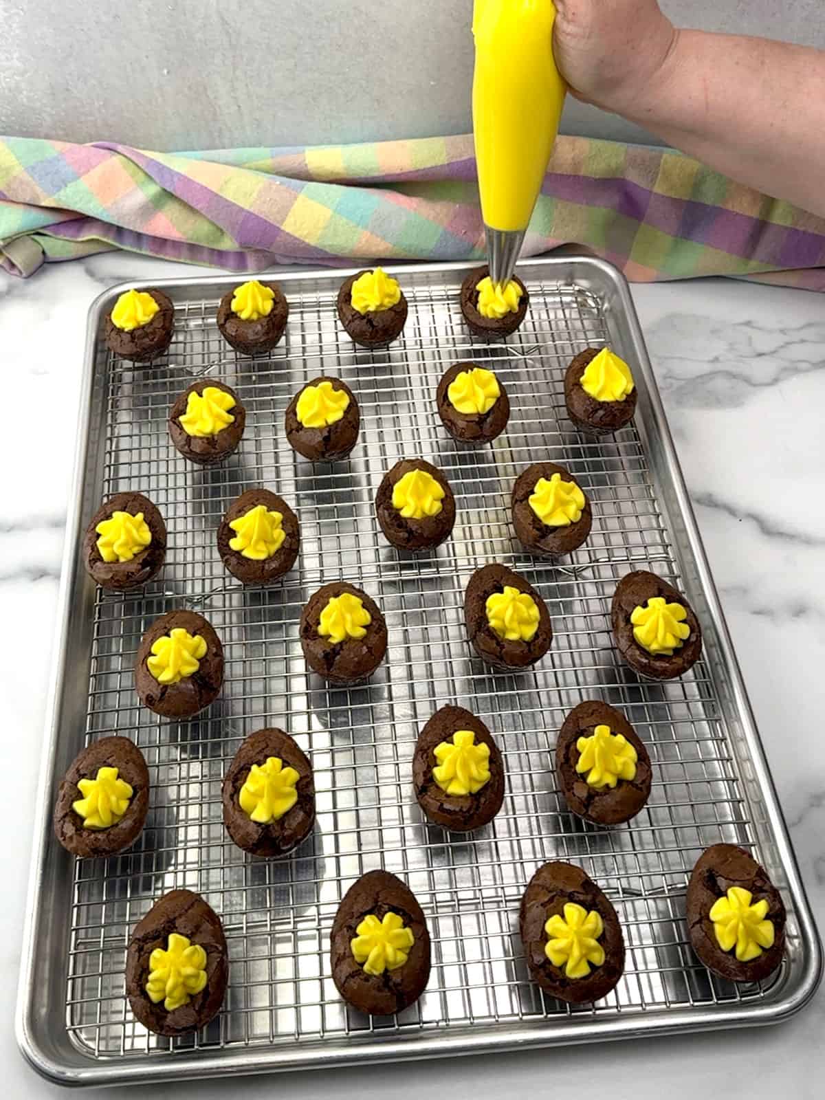 filling each brownie egg with frosting