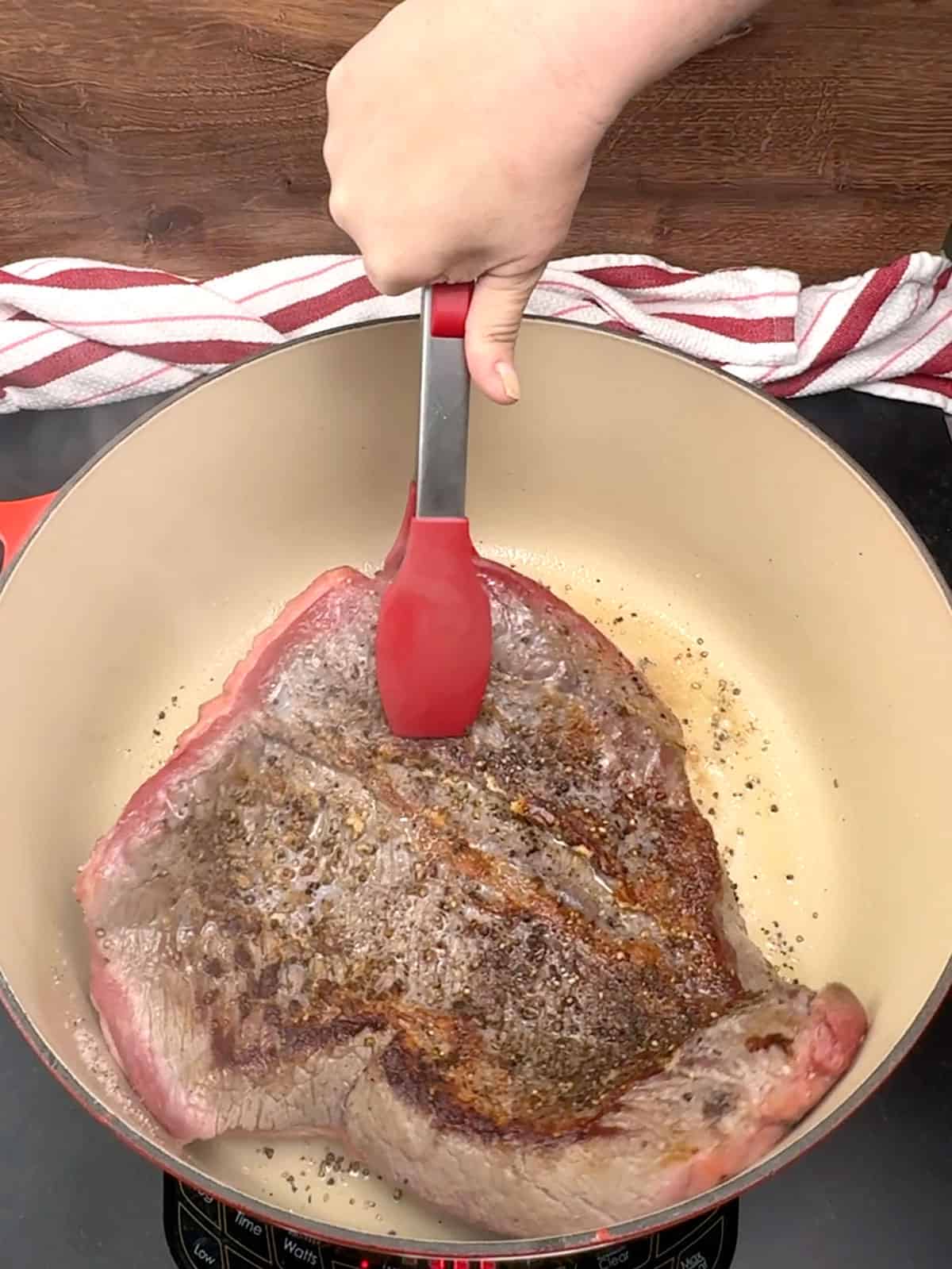 flipping brisket over in pot to sear the other side