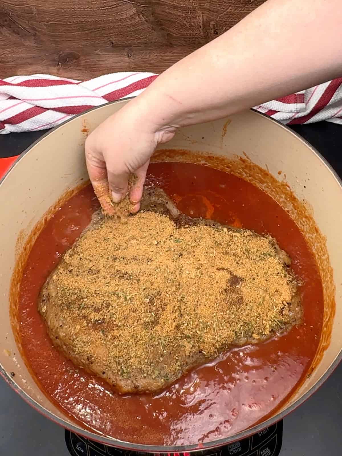 sprinkling herb mixture over the brisket in pot
