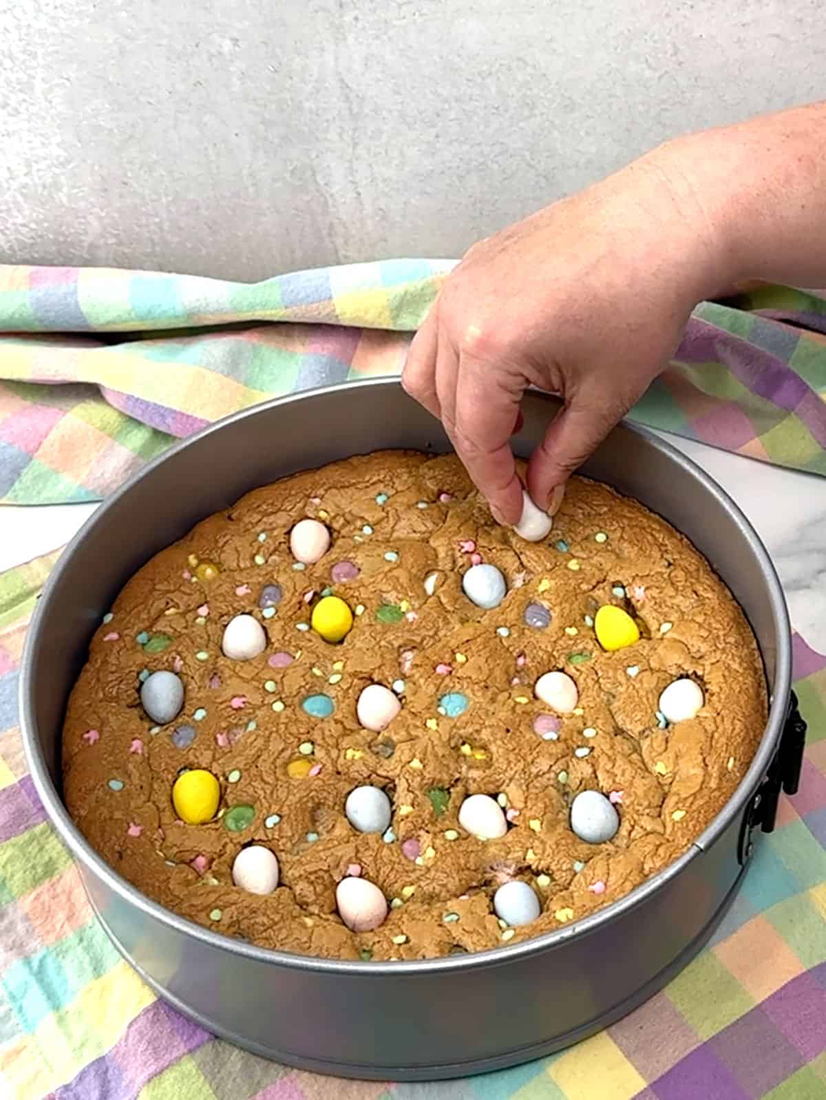 pressing additional Cadbury Mini eggs into the baked cookie cake