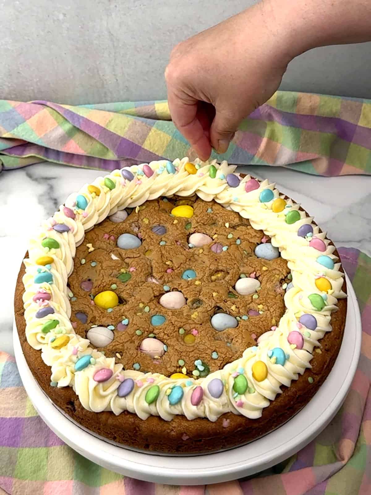 topping frosting with M&M's and sprinkles