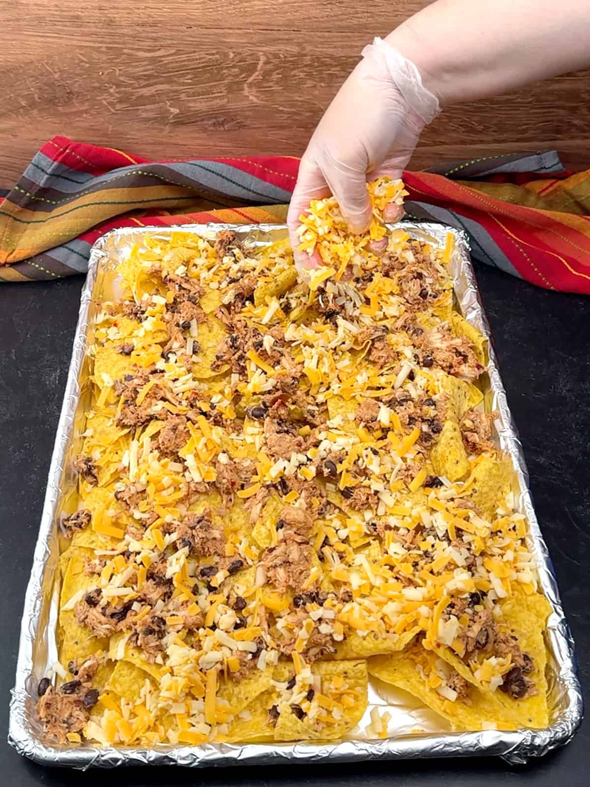 sprinkling first half of cheese over the top