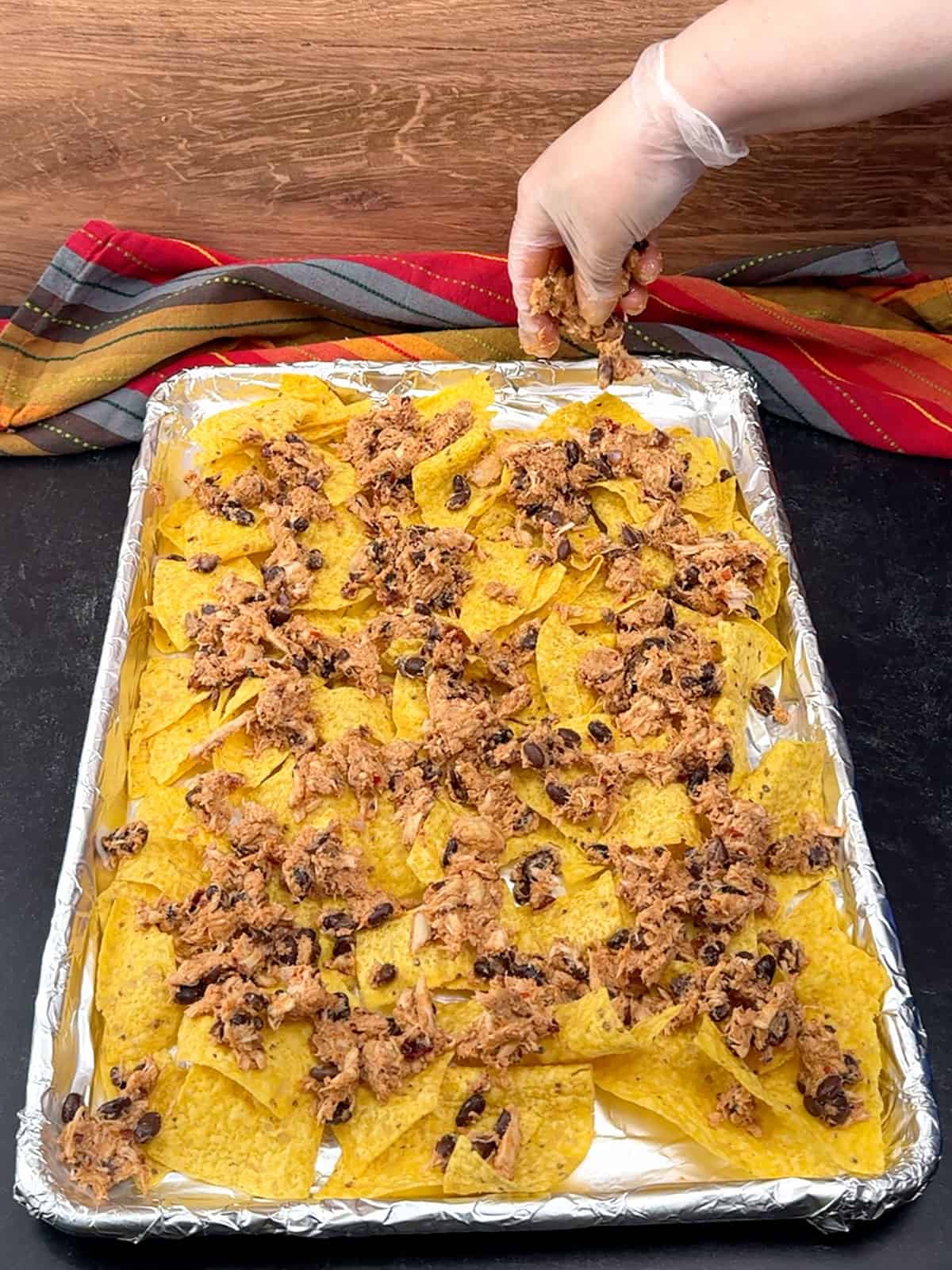 sprinkling first half of chicken mixture over tortilla chips