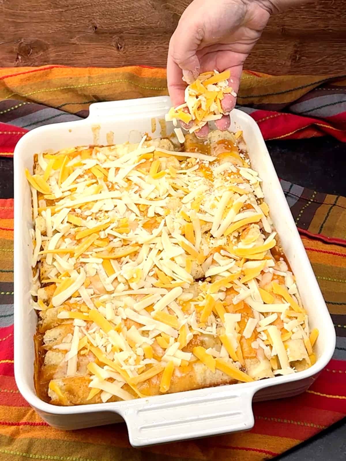 sprinkling remaining cheese over taquito casserole after baking for 20 minutes